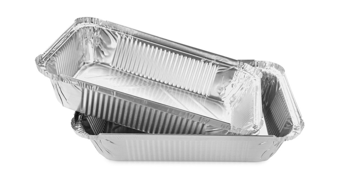 Two empty, wrinkled aluminum pans are stacked together against a white background, revealing their ridged rectangular shapes.
