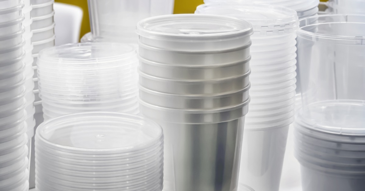 Multiple stacks of clear and frosted plastic cups and containers in various sizes against a yellow background. Multiple stacks of clear and frosted plastic cups and containers in various sizes against a yellow background.