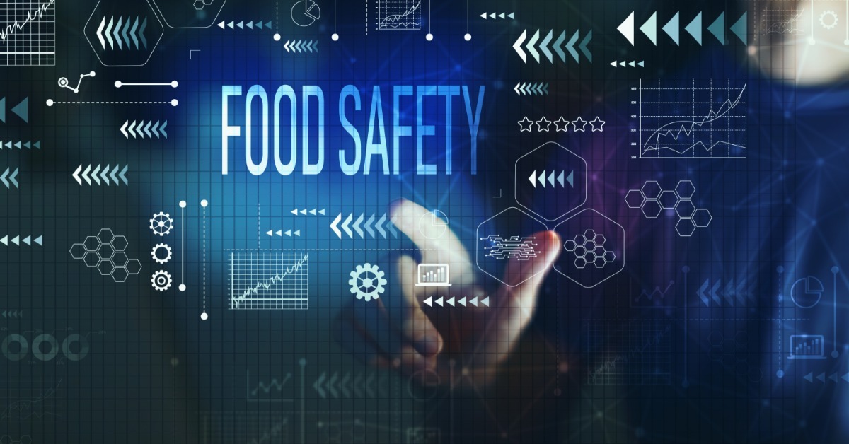 A person touches a digital interface with 'Food Safety' text surrounded by data icons and tech graphics.